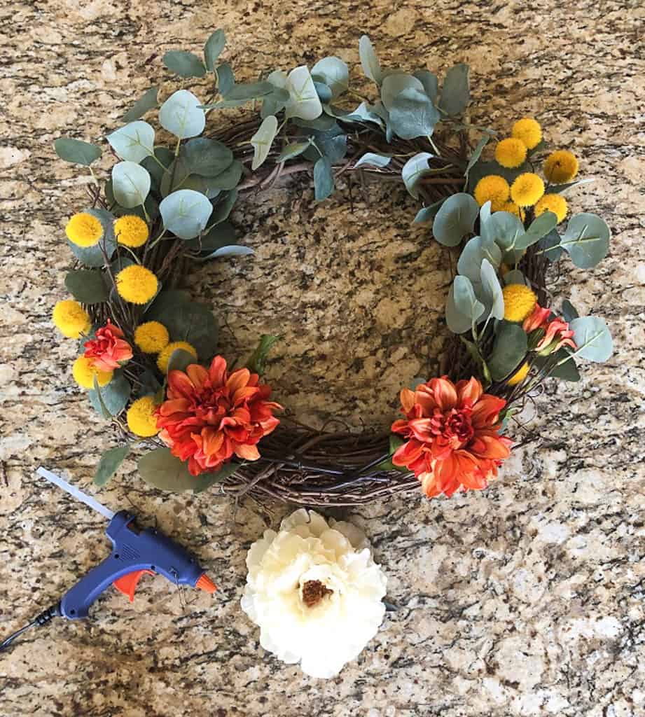 Use hot glue to glue the flowers at the center base of the wreath. 