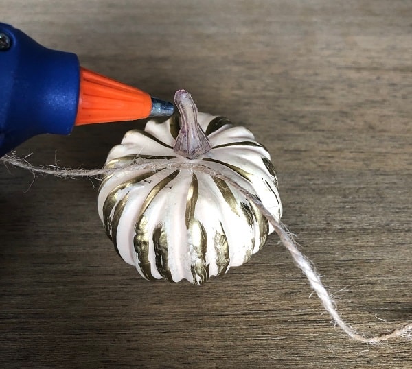Use hot glue to tie your pumpkins to your fall garland. 