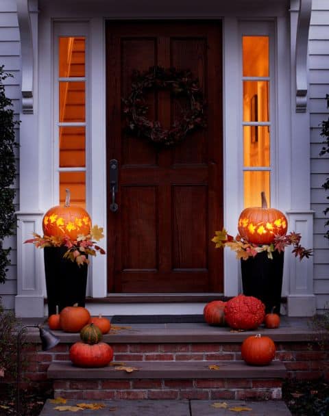 Carve out pumpkins and let them glow on top of a planter. 