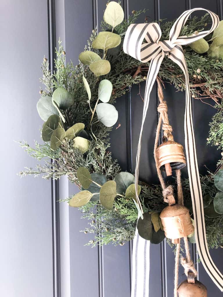 DIY Christmas Wreath Tutorial using a grapevine wreath, faux pine and eucalyptus, ribbon and brass bells. 