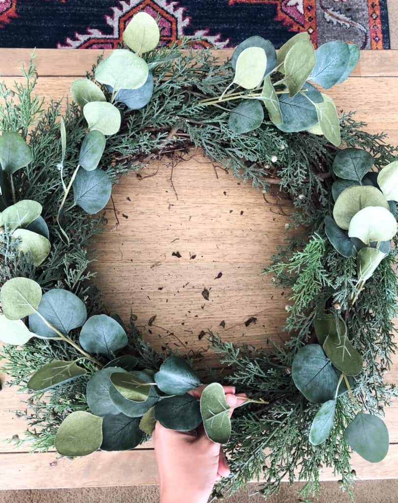 Tuck each eucalyptus stem into your Christmas wreath until it is covered all around the wreath. 